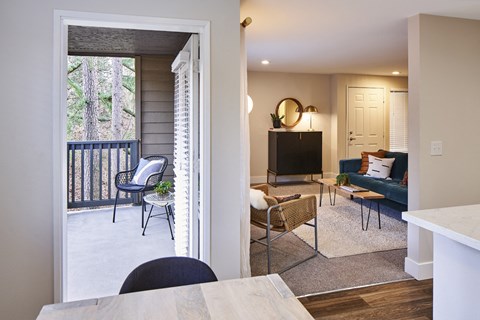 a living room with a couch and a tv and a balcony